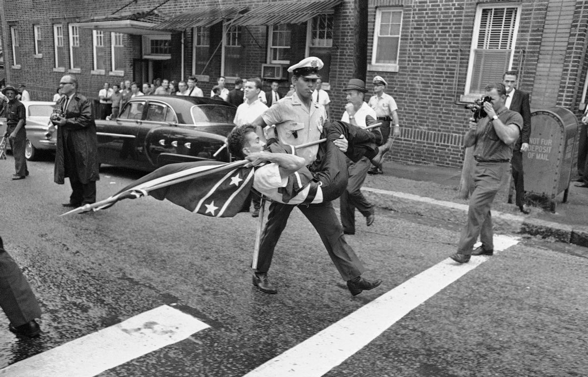 FILE - In this Sept. 4, 1963, file photo, a police officer carries off a demonstrator holding a Confederate flag after a group of demonstrators protested enrollment of two African-Americans at Ramsay High School in Birmingham, Ala. The Confederate battle flag has been removed from South Carolina's Statehouse grounds, in the wake of the massacre of nine African-Americans, including a state senator, at an historic black church in Charleston in June 2015. (AP Photo/File) (AP)