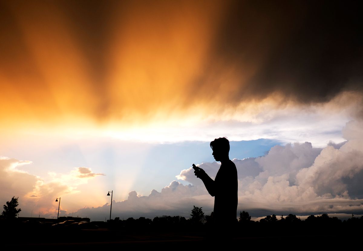AP10ThingsToSee - A teenager checks his cell phone as storm clouds pass Friday, July 17, 2015, in Zionsville, Ind. Scattered storms were in the forecast for most of Friday evening. (AP Photo/Darron Cummings) (AP)