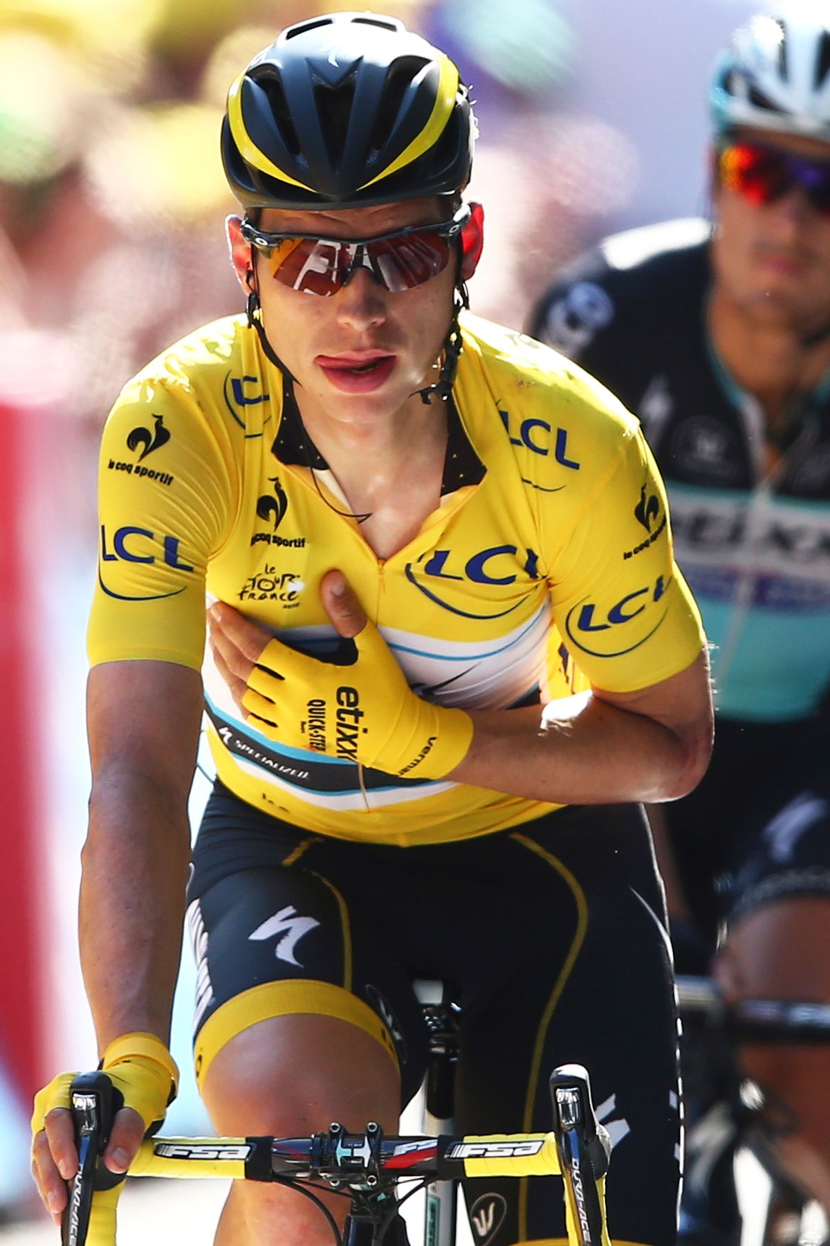 Germany's Tony Martin, wearing the overall leader's yellow jersey, holds his arm in a position which stabilizes his shoulder and collar bone as he crosses the finish line of the sixth stage of the Tour de France cycling race over 191.5 kilometers (119 miles) with start in Abbeville and finish in Le Havre, France, Thursday, July 9, 2015.(AP Photo/Peter Dejong)  (Peter Dejong)