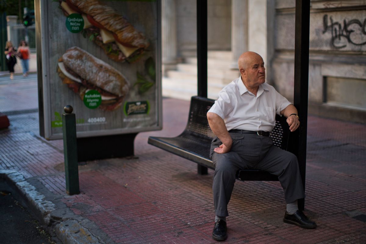 A man waits for public transportation sitting at a bus station in central Athens, Wednesday, July 8, 2015. Frustrated and angry eurozone leaders fearing for the future of their common currency gave the Greek Prime Minister Alexis Tsipras a last-minute chance Tuesday to finally come up with a viable proposal on how to save his country from financial ruin. (AP Photo/Emilio Morenatti) (AP)