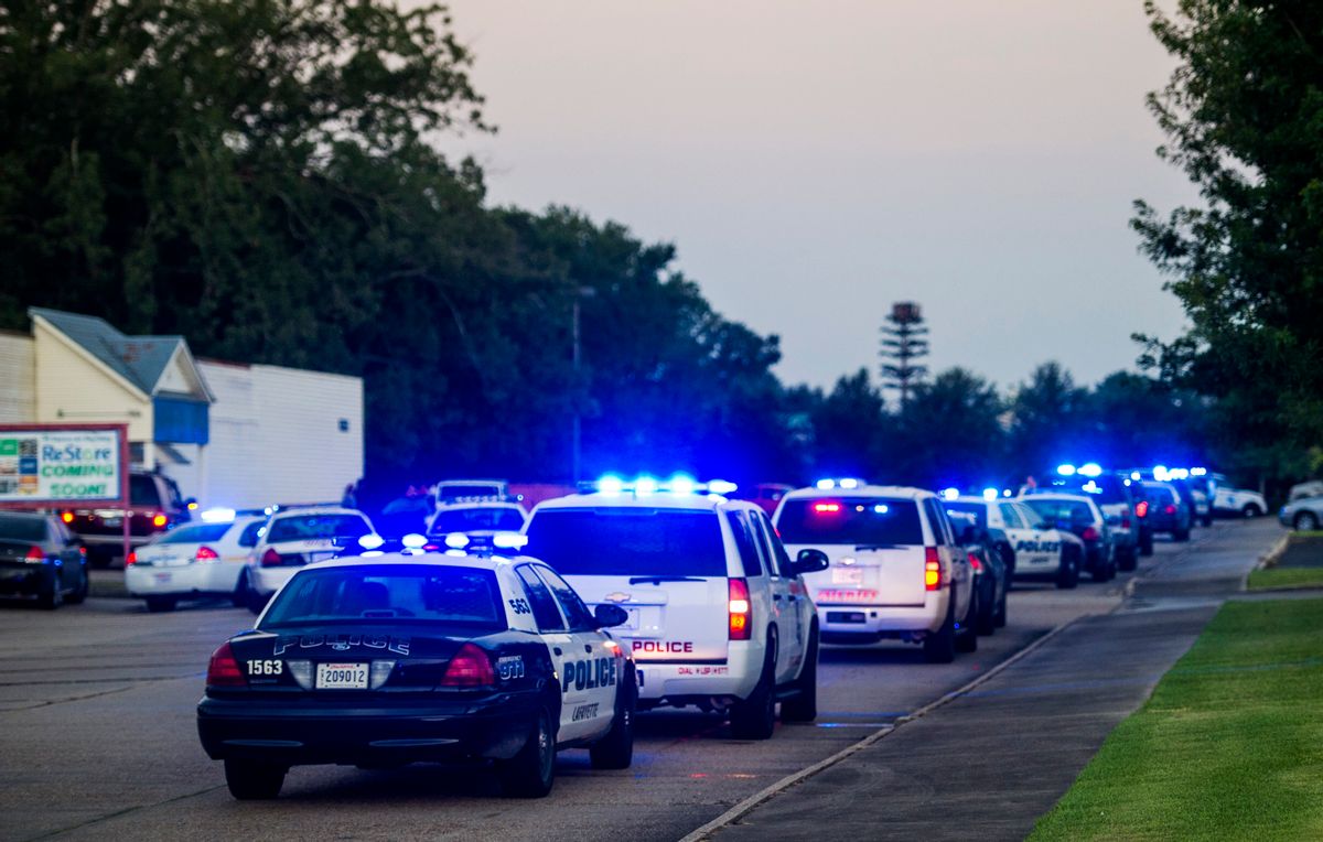 Lafayette Police Department and Louisiana State Police units block an entrance road following a shooting at The Grand Theatre in Lafayette, La., Thursday, July 23, 2015. (Paul Kieu/The Daily Advertiser via AP) (AP)
