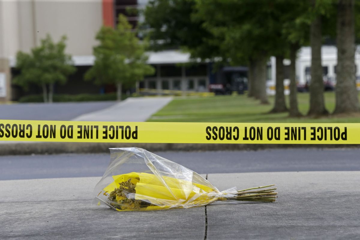 A bouquet of flowers lies net crime scene tape in the parking lot outside The Grand 16 movie theater in Lafayette, La.   (AP/Gerald Herbert)