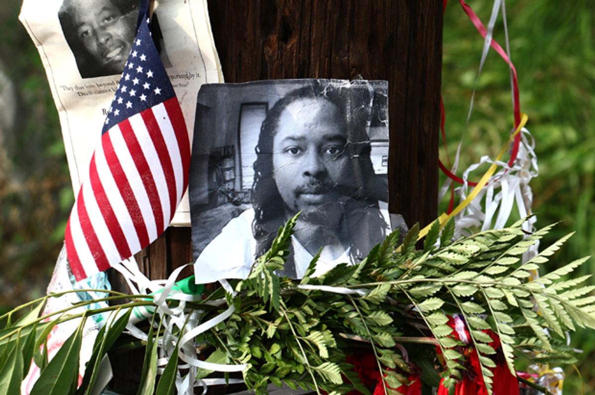 Photos of Samuel DuBose hang on a pole at a memorial, Wednesday July 29, 2015 in Cincinnati, near where he was shot and killed by a University of Cincinnati police officer.        (AP/Tom Uhlman)