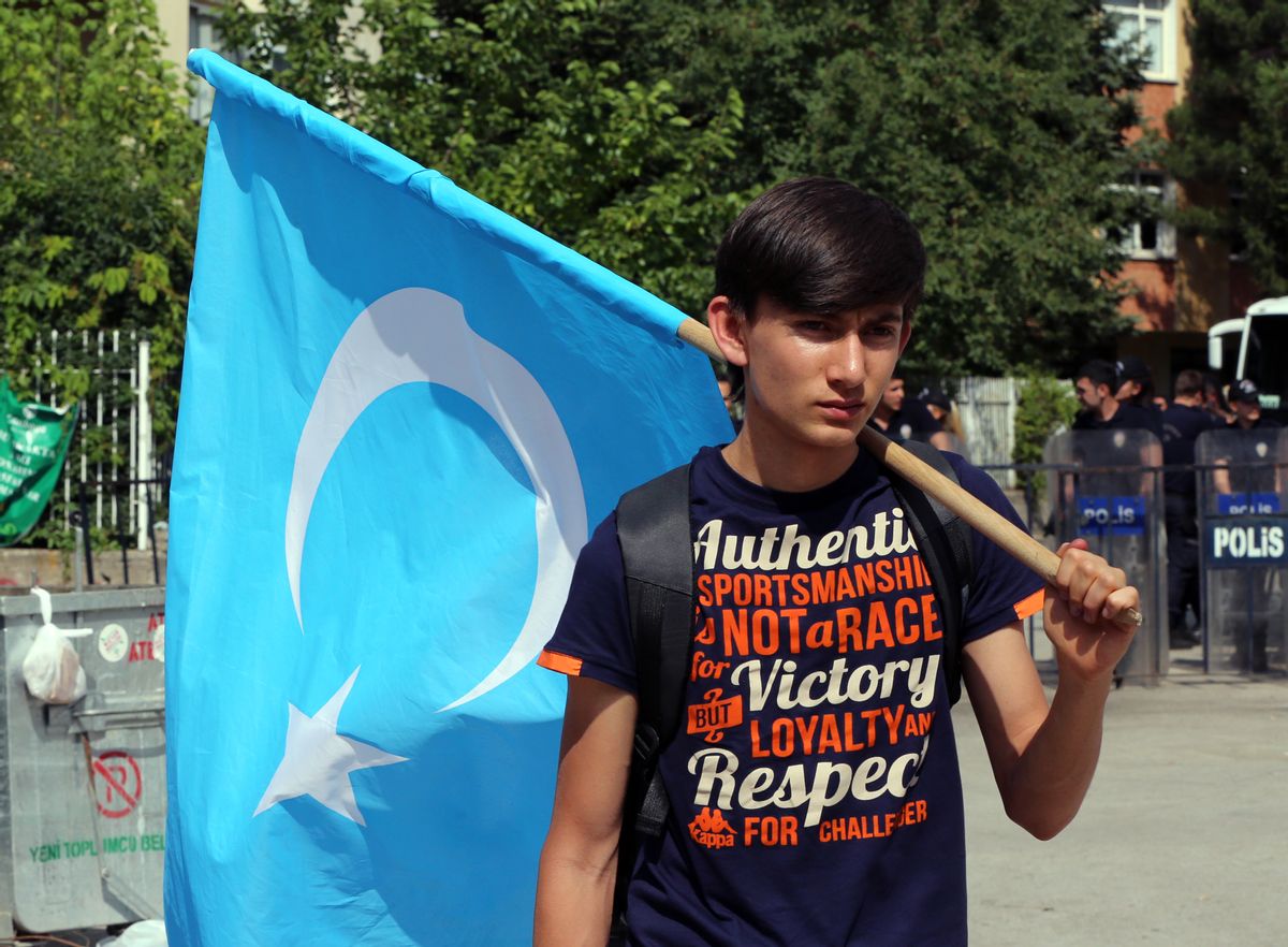 An Uighur boy carries a flag of  East Turkestan, the term separatist Uighurs and Turks use to refer to the Uighurs' homeland in China's Xinjiang region,after the riot police used pepper spray to push back a group of Uighur protesters who try to break through a barricade outside the Chinese Embassy in Ankara, Turkey, Thursday, June 9. 2015. Thailand sent back to China more than 100 ethnic Uighur refugees on Thursday, drawing harsh criticism from the U.N. refugee agency and human rights groups over concerns that they face persecution by the Chinese government. Protesters in Turkey, which accepted an earlier batch of Uighur refugees from Thailand, ransacked the Thai Consulate in Istanbul overnight.(AP Photo/Burhan Ozbilici) (AP)