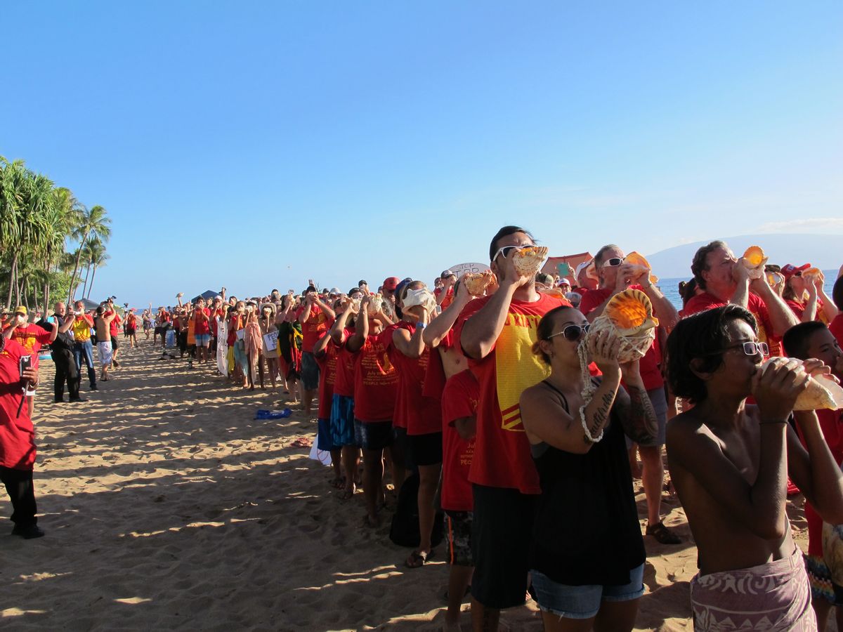 Hundreds of protestors blowing conch shells line Kaanapali Beach in Lahaina, Hawaii, Wednesday, July 29, 2015, to protest the Trans-Pacific Partnership trade agreement. Ministers from 12 Pacific Rim nations are gathering at the Westin Maui resort on the beach to negotiate a new trade pact. (AP Photo/Audrey McAvoy) (AP)