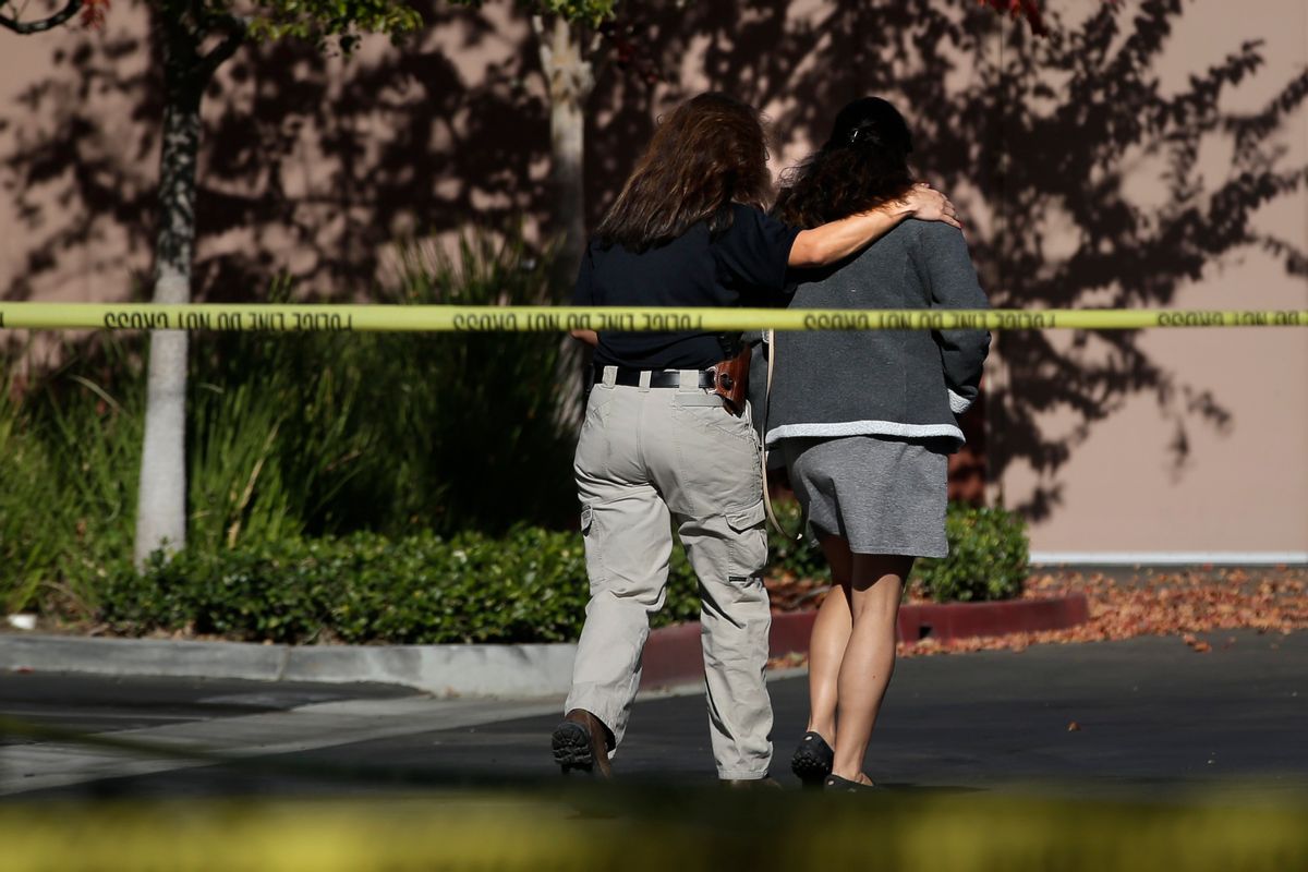 An unidentified woman, right, is comforted by an investigator at the Inland Regional Center, the site of  shooting rampage that killed 14 people, Tuesday, Dec. 8, 2015, in San Bernardino, Calif.  ((AP Photo/Jae C. Hong))