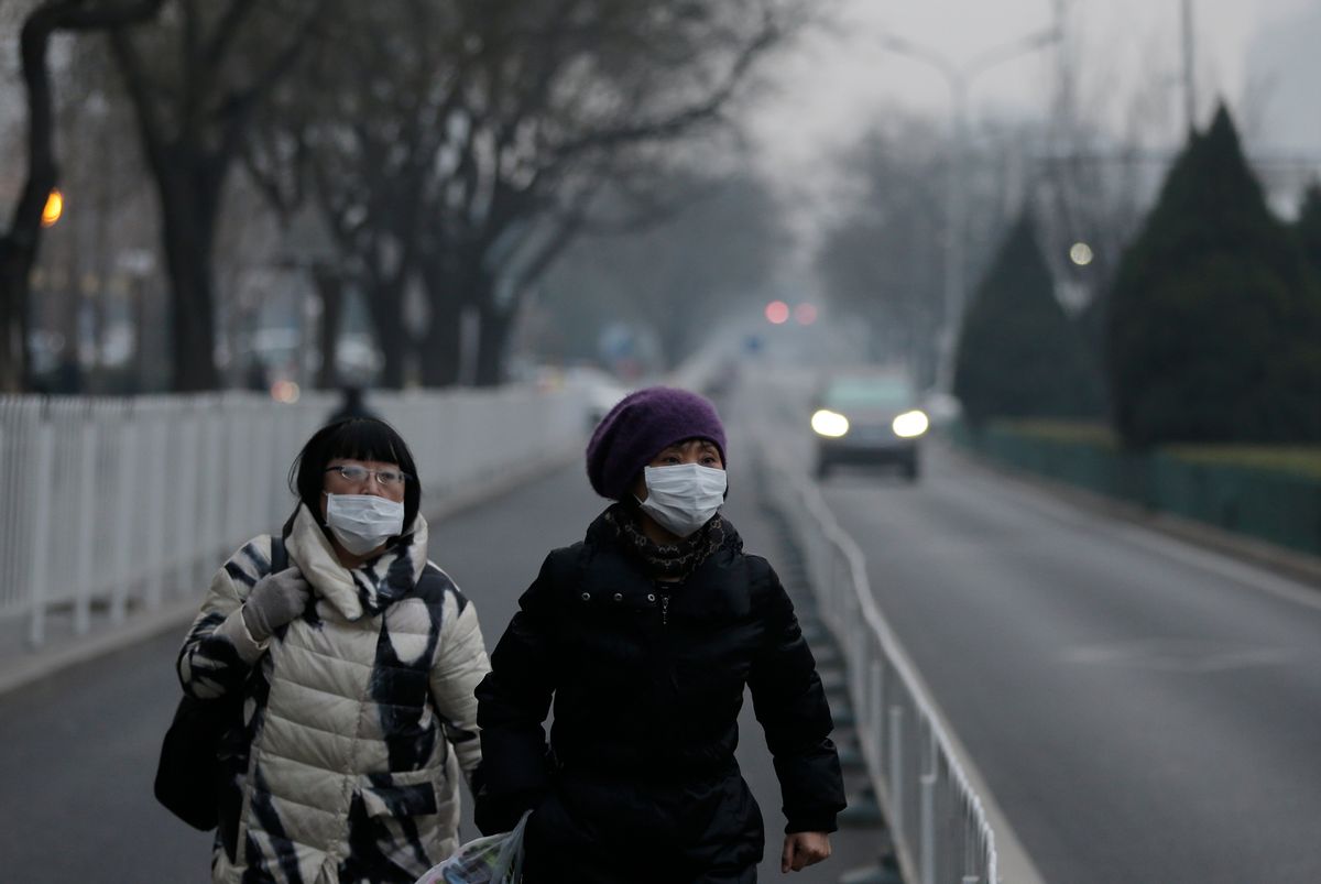 Women wear masks as they walk along a street on a polluted day in Beijing, Sunday, Dec. 13, 2015. China's push for a global climate pact is partly because of its own increasingly pressing need to solve serious environmental problems, observers said Sunday. (AP Photo/Andy Wong) (AP)