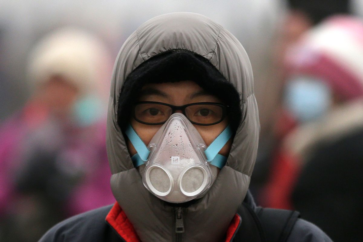 In this Dec. 1, 2015 photo, a woman wears a mask to protect herself from pollutants near Tiananmen Gate on a heavily polluted day in Beijing. Episodes of nauseating smog lasting several days has become part of wintertime in the Chinese capital, and for many Beijing residents face masks have become a routine cold-weather accessory, along with hats and gloves.  (AP Photo/Andy Wong) (AP)