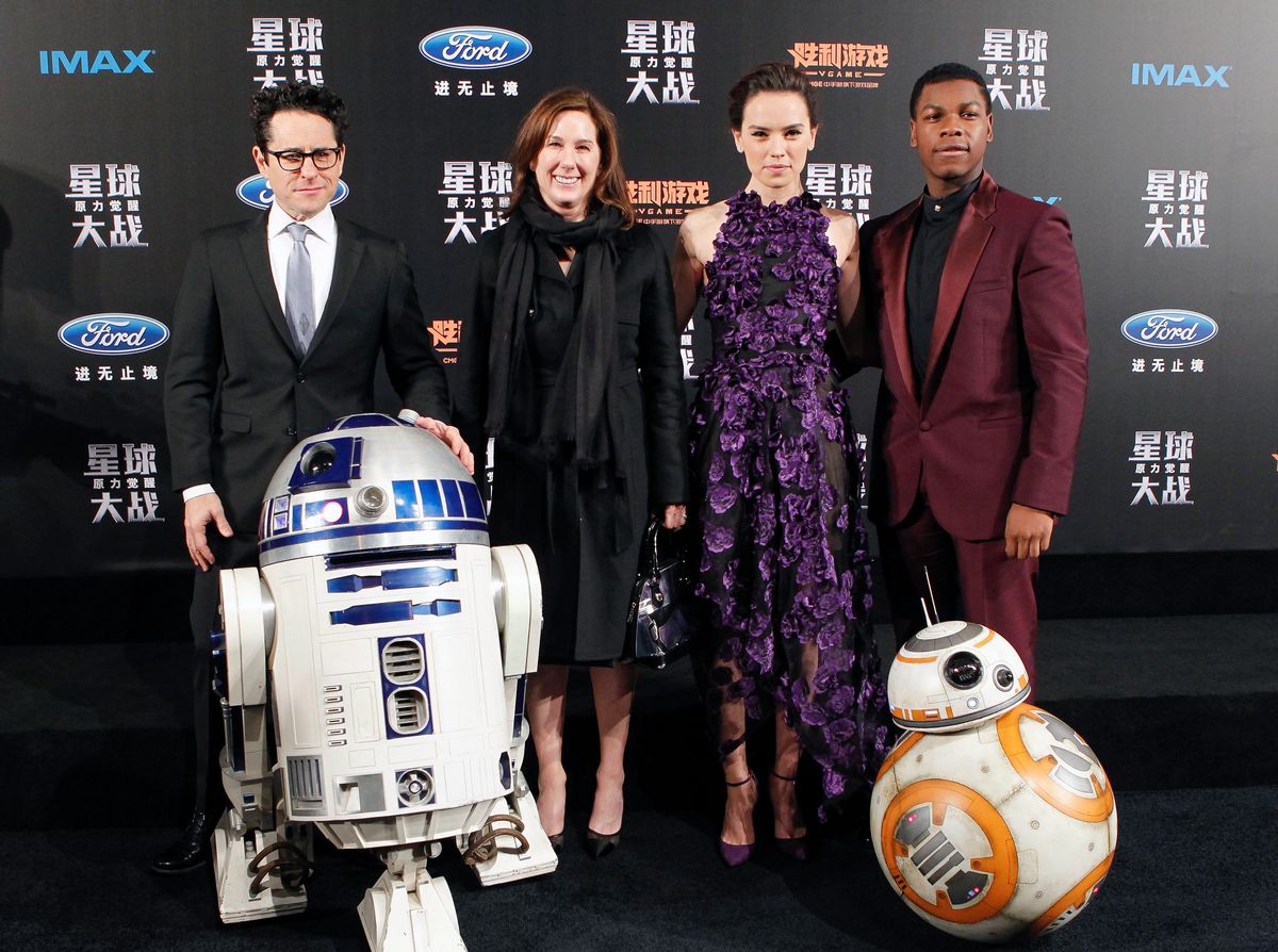 From left, director J.J. Abrams, producer Kathleen Kennedy, actress Daisy Ridley and actor John Boyega pose with droids character BB-8 and R2-D2 on stage during the premiere of "Star Wars: The Force Awakens" in Shanghai, China, Sunday, Dec. 27, 2015. (Chinatopix via AP) CHINA OUT (AP)