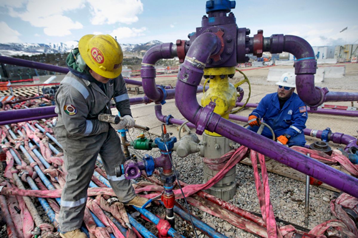 Workers tend to a well head during a hydraulic fracturing operation outside Rifle, in western Colorado, March 29, 2013.   (AP/Brennan Linsley)