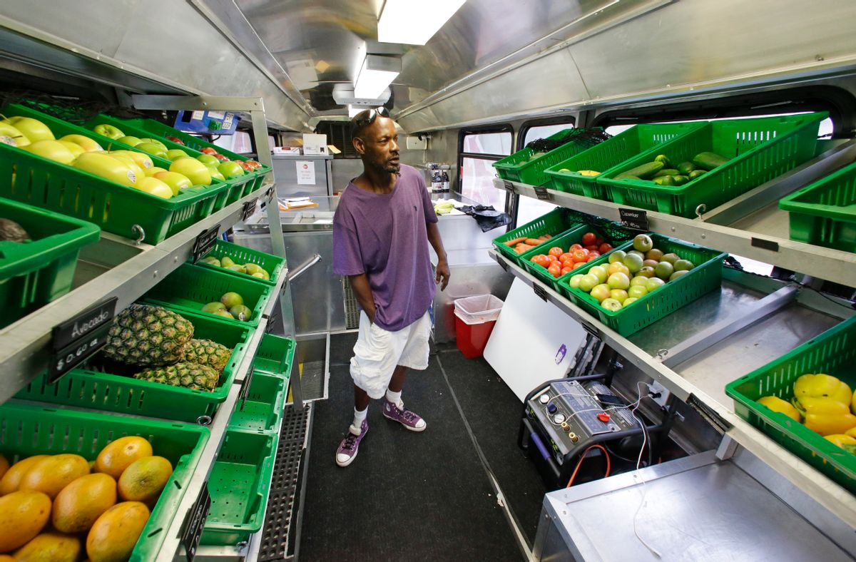 In this Wednesday, July 15, 2015 photo,Jock Riggins looks over the fresh fruits and vegetables on the Fresh Stop bus, a mobile market, in Eatonville, Fla.  The Fresh Stop brings fresh fruits and vegetables to communities with no supermarkets. The nations largest grocery chains have built new supermarkets in only a fraction of the neighborhoods where theyre needed most, according to an analysis of federal food stamp data by The Associated Press. (AP Photo/John Raoux) (AP)