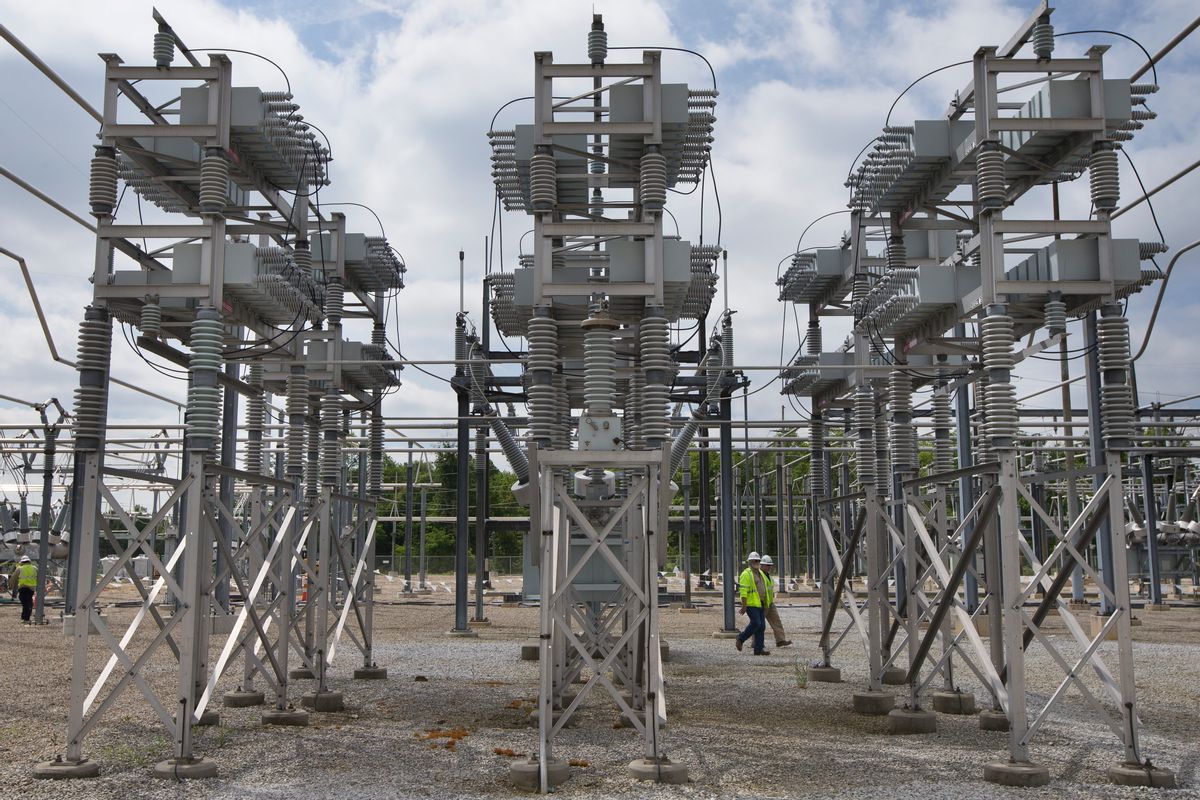 In this Wednesday, May 20, 2015 photo, contractors walk past a capacitor bank at an AEP electrical transmission substation in Westerville, Ohio. (AP Photo/John Minchillo) (AP)