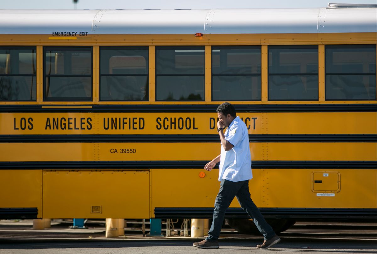A Los Angeles Unified School District bus driver walks past parked vehicles at a bus garage in Gardena, Calif., on Tuesday, Dec. 15, 2015. The nation's two biggest school systems, New York City and Los Angeles, received threats of a large-scale attack Tuesday, and L.A. reacted by shutting down the entire district. New York dismissed the warning as an amateurish hoax and held class as usual. In LA, the threat came in the form of an email to a school board member that raised fears of another attack like the recent deadly shooting in nearby San Bernardino. (AP Photo/Damian Dovarganes) (AP)