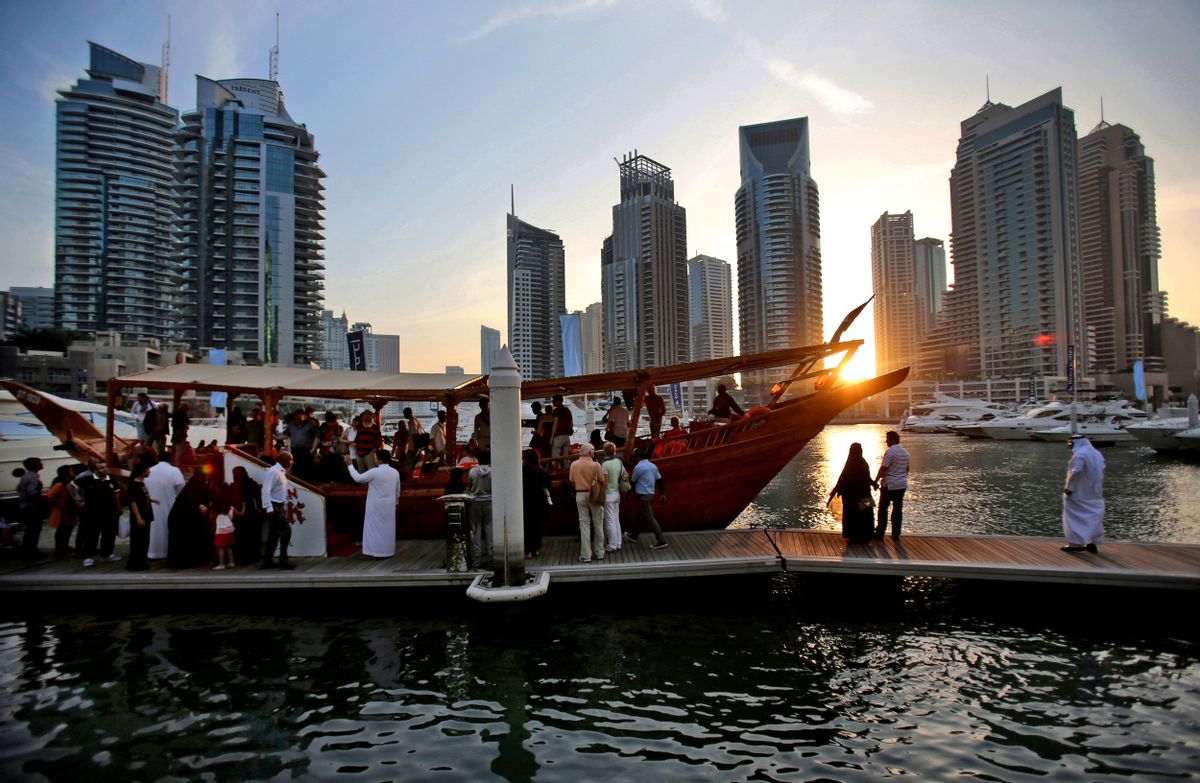 In this March 25, 2015 photo, tourists of different nationalities board a dhow for a cruise as the sun sets in the Marina neighborhood of Dubai, United Arab Emirates. Dubais year-round sunshine gives the Marina a summer-vibe throughout the winter months, when temperatures rarely drop below a comfortable 75 degrees Fahrenheit (24 Celsius) during the day. (AP Photo/Kamran Jebreili) (AP)