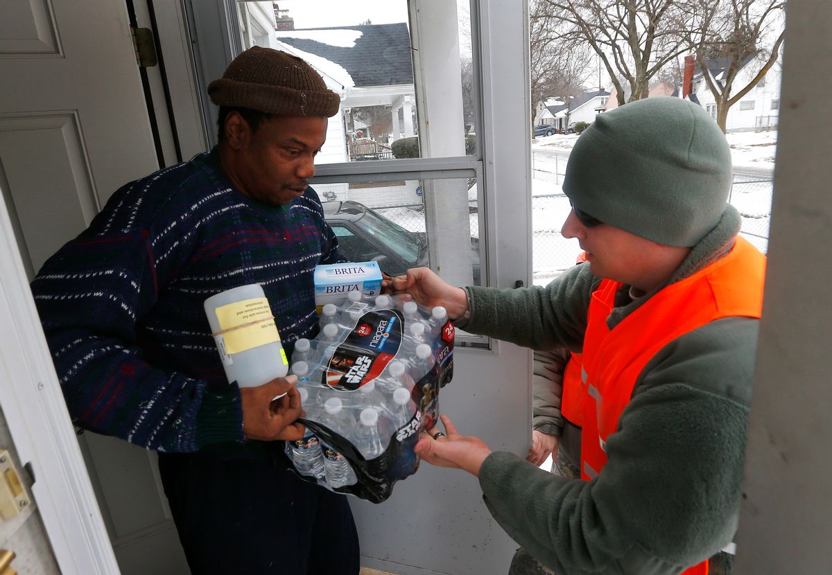 Louis Singleton receives water filters, bottled water and a test kit from Michigan National Guard Specialist Joe Weaver as clean water supplies are distributed to residents, Thursday, Jan. 21, 2016 in Flint, Mich. The National Guard, state employees, local authorities and volunteers have been distributing lead tests, filters and bottled water during  the city's drinking water crisis.  (AP Photo/Paul Sancya) (AP)