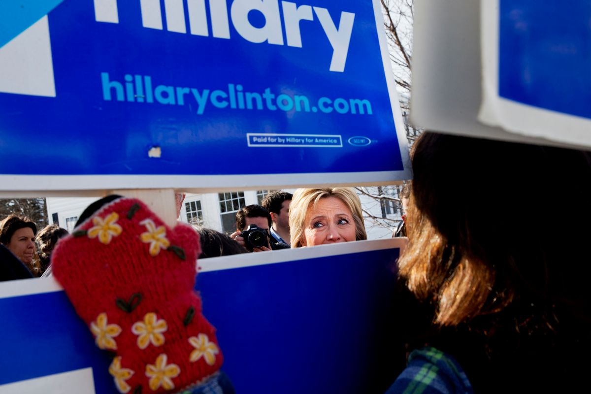 Democratic presidential candidate Hillary Clinton peeks through signs of hers as she greets supporters during a campaign stop in a Manchester, N.H. (AP)