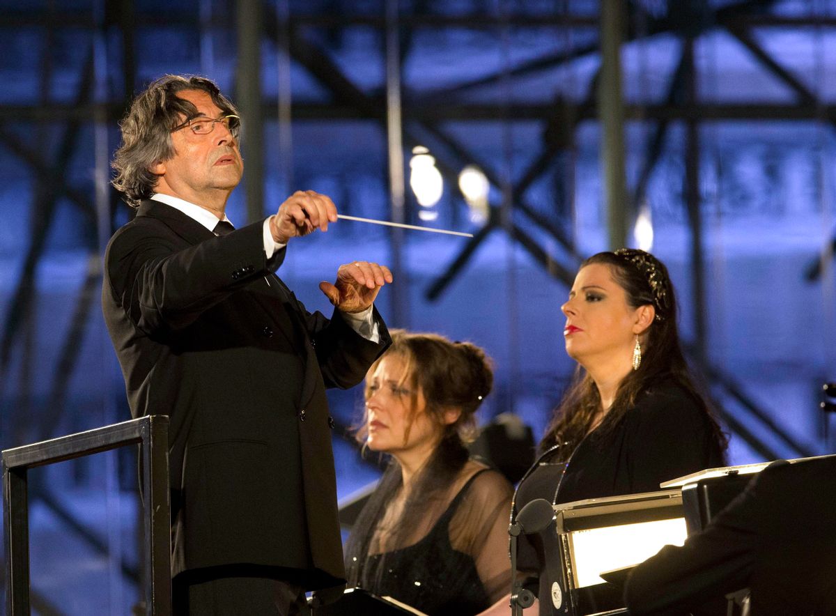 In this photo taken on Sunday, July 6, 2014, Riccardo Muti, left, directs Giuseppe Verdi's Requiem Mass during a concert commemorating the 100th anniversary of the outbreak of World War I, at the Redipuglia War Memorial in Fogliano Redipuglia, Italy. Conductor Riccardo Muti is the musical director of the Chicago Symphony Orchestra. (AP Photo/Paolo Giovannini) (AP)