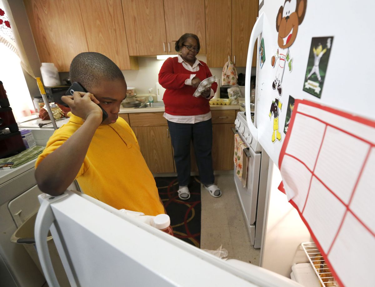 In this Jan. 29, 2016, photo, Debra Aldridge, right, continues to make dinner as her grandson Mario Hendricks talks to a cousin about being able to go to a sleep-over at the cousin's home, at her home on Chicago's South Side. Nationwide, there are 2.7 million grandparents raising grandchildren. About a fifth have incomes that fall below the poverty line, according the Census figures. More grandparents are taking on the role of parents for their grandkids, as social service agencies try to place foster children in so-called kinship families. (AP Photo/Charles Rex Arbogast) (AP)