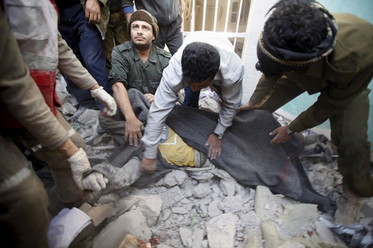 Yemeni police and medics cover the body of a dead man after the Saudi-led coalition bombed the police headquarters in Yemen's capital Sanaa, on January 18, 2016  (Reuters/Khaled Abdullah)