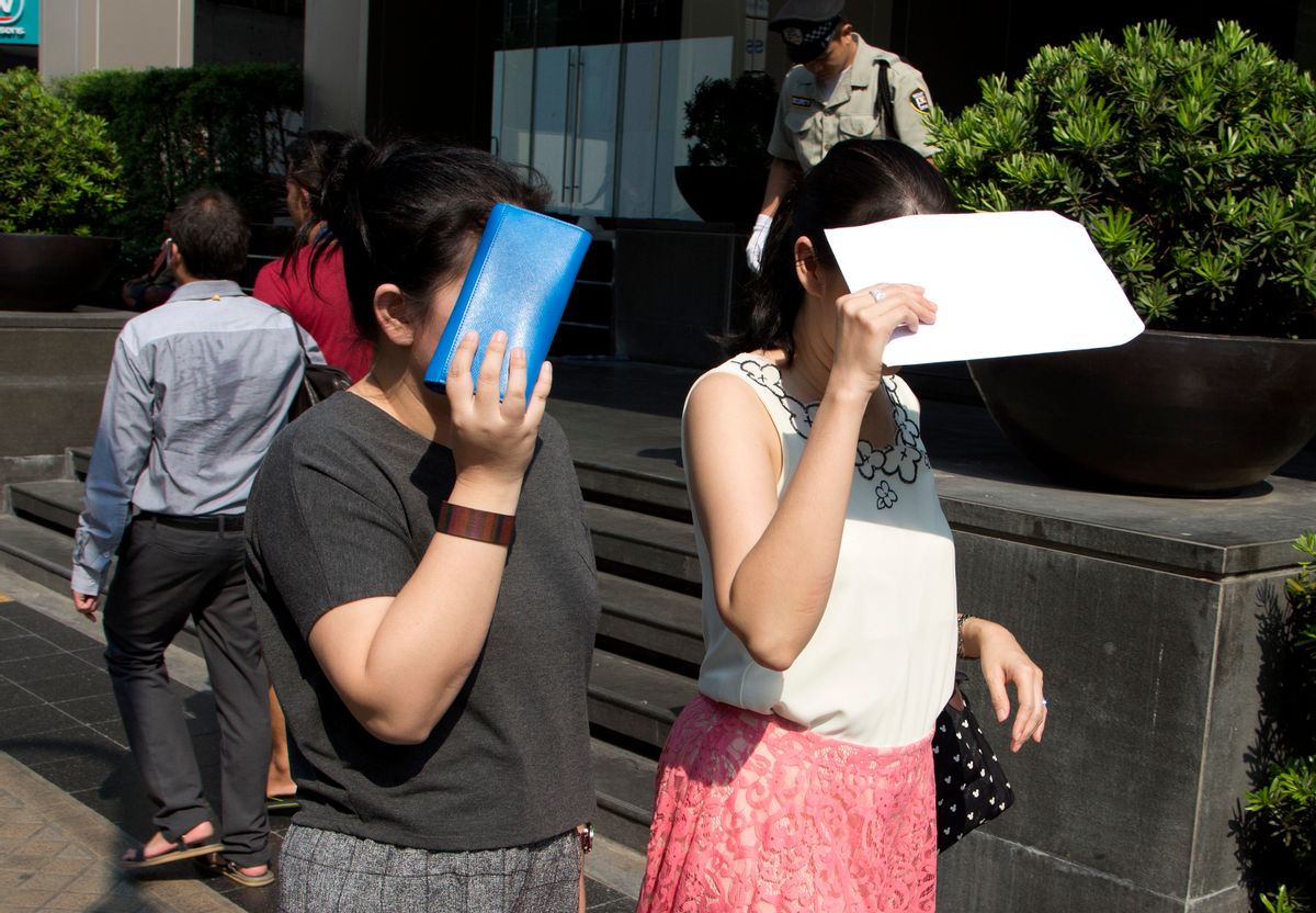 Pedestrians protect themselves from the sun while walking in central Bangkok, Thailand, Wednesday, April 27, 2016.  (AP Photo/Mark Baker)