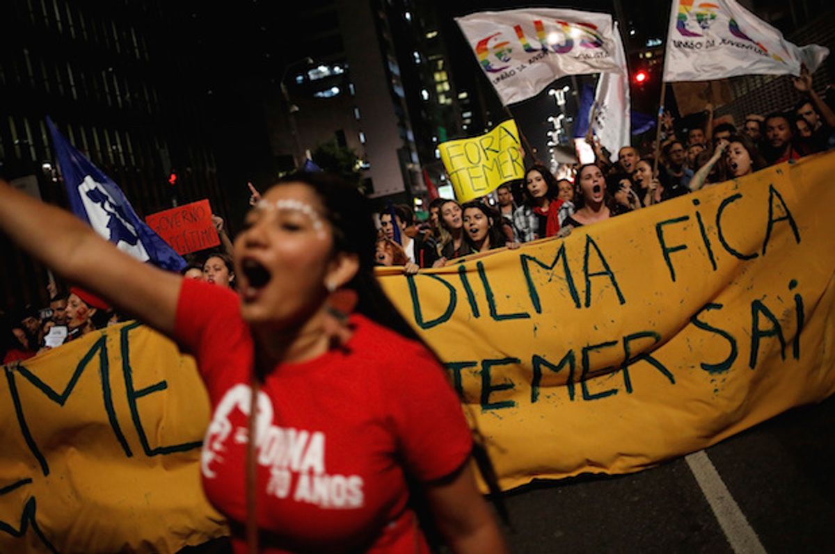 Women shout slogans during a protest against Brazil's interim President Michel Temer and in support of suspended President Dilma Rousseff in Sao Paulo, Brazil, on May 17, 2016. The banner reads "Dilma stays, Temer out"  (Reuters/Nacho Doce)