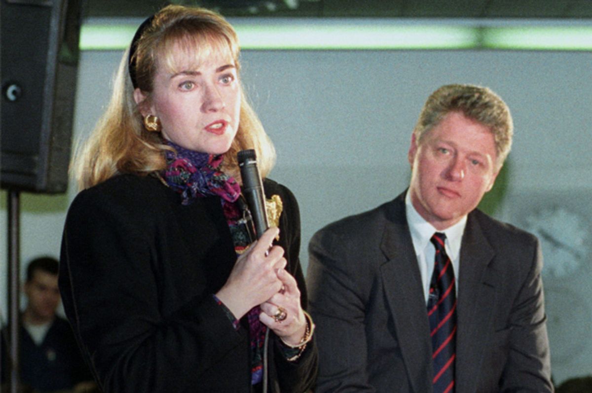 Bill Clinton listens as Hillary Clinton addresses a group at Maine South High School in the Chicago suburb of Park Ridge, March 11, 1992.    (Reuters/Sue Ogrocki)