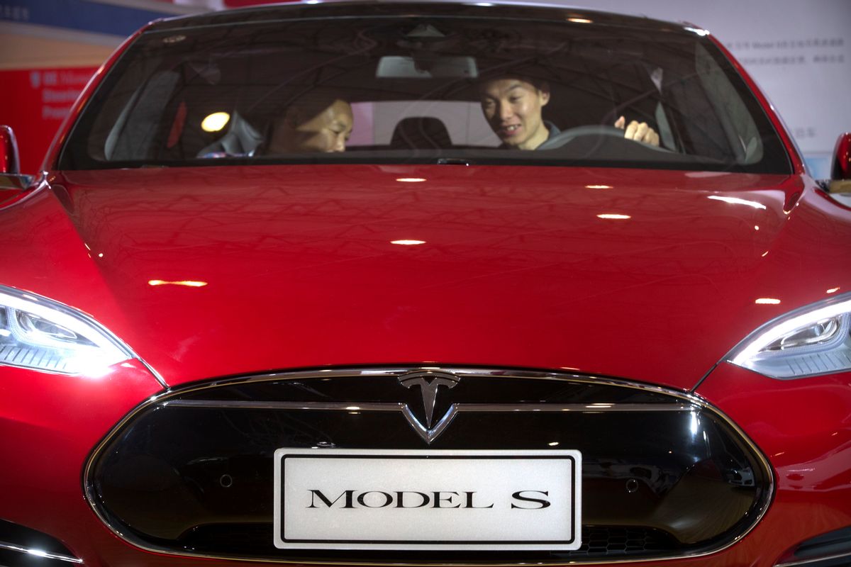 FILE - In this Monday, April 25, 2016, file photo, a man sits behind the steering wheel of a Tesla Model S electric car on display at the Beijing International Automotive Exhibition in Beijing. Tesla reports financial results Wednesday, May 4, 2016. (AP Photo/Mark Schiefelbein, File) (AP)