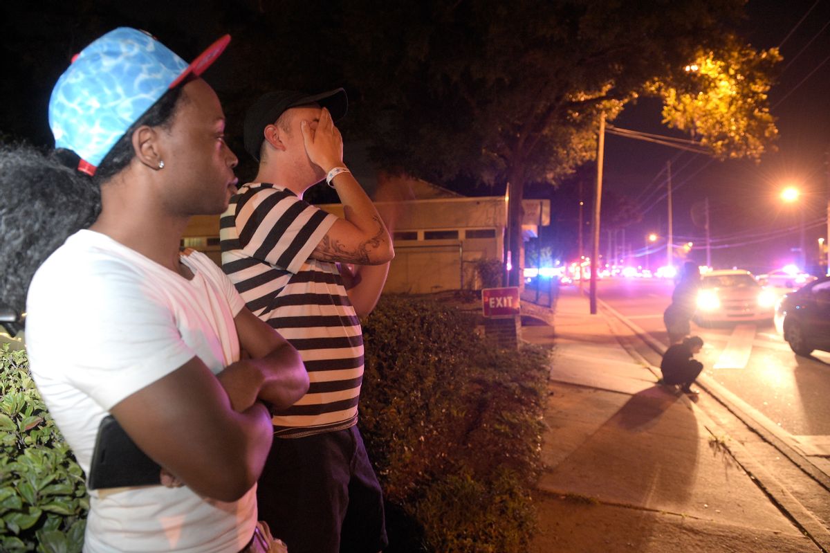 Jermaine Towns, left, and Brandon Shuford wait down the street from a multiple shooting at a nightclub on Sunday (AP)