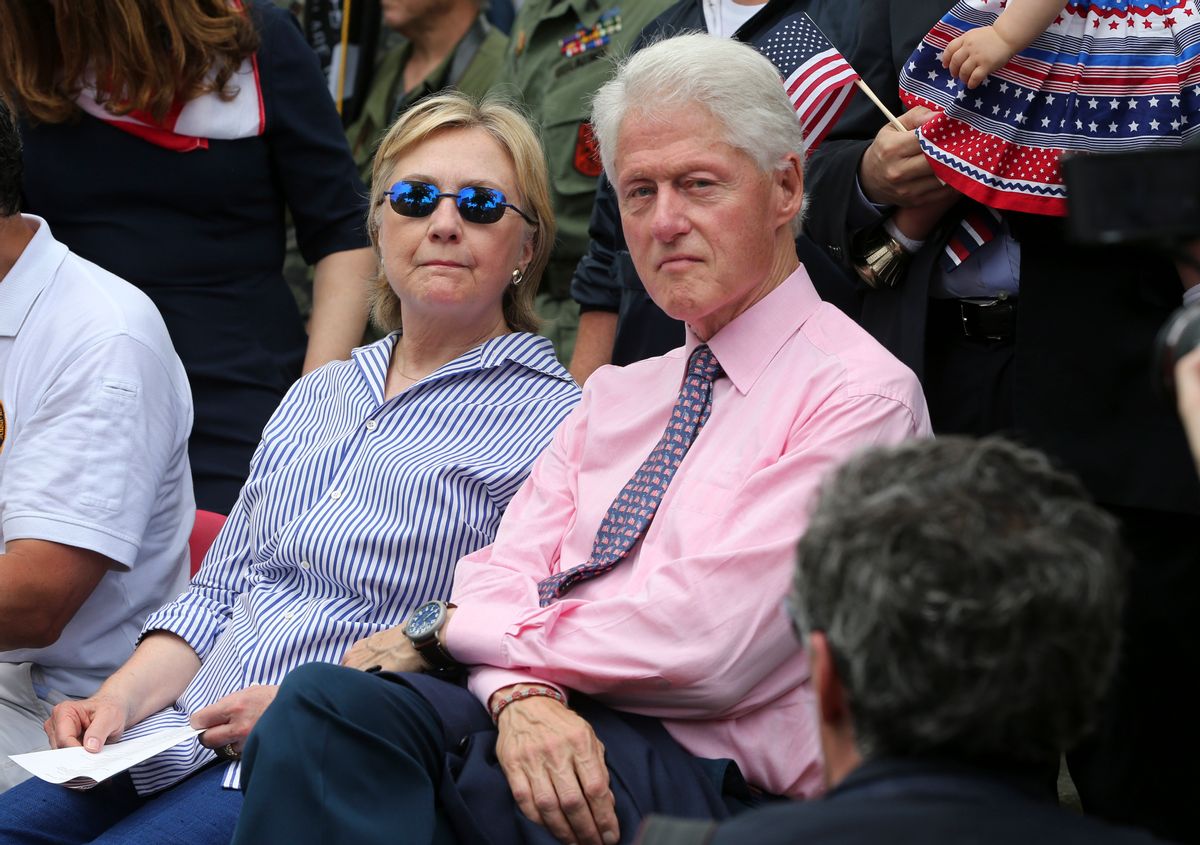 Hillary Clinton sits with her husband former President Bill Clinton as they attend a ceremony after walking in a Memorial Day parade (AP)