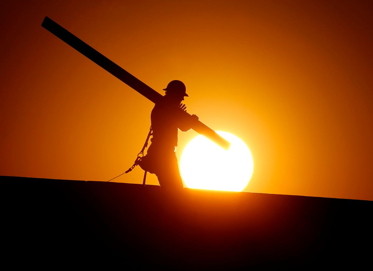 A home builder works at sunrise, Monday, June 20, 2016, in Gilbert, Ariz., in an effort to beat the rising temperatures. (AP Photo/Matt York)