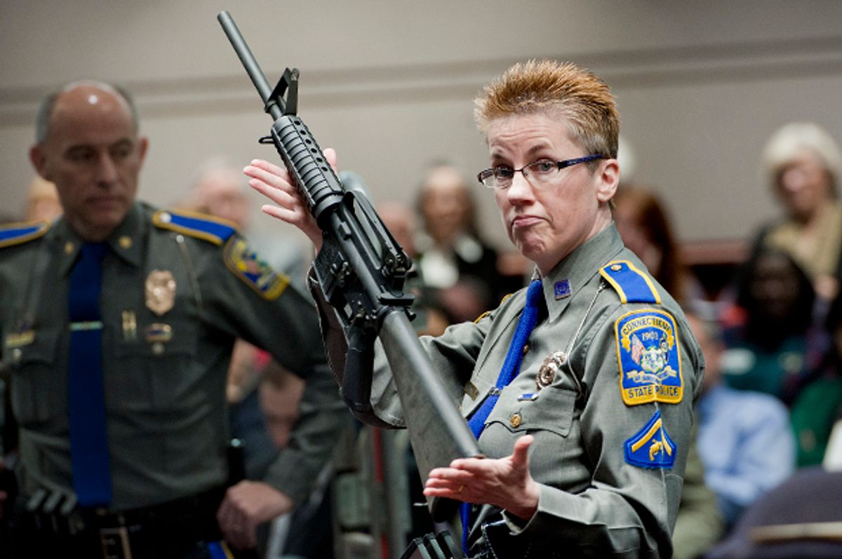 Detective Barbara J. Mattson, of the Connecticut State Police, holds up a Bushmaster AR-15 rifle, the same make and model of gun used by Adam Lanza in the Sandy Hook School shooting, Jan. 28, 2013.   (AP/Jessica Hill)