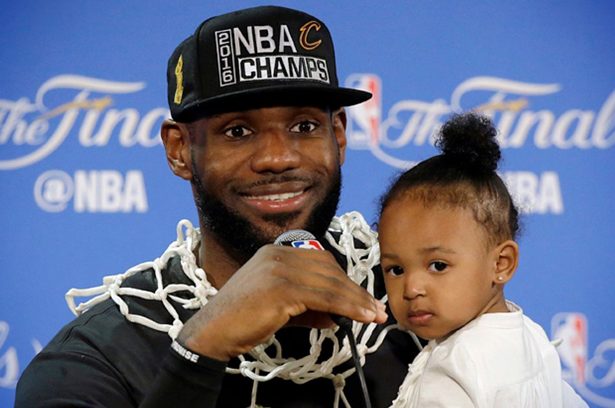 LeBron James answers questions as he holds his daughter Zhuri during a post-game press conference, June 19, 2016, in Oakland.   (AP/Eric Risberg)