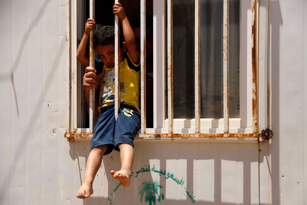 A man holds a child in the window of a shelter at the Zaatari refugee camp in northern Jordan, Sunday, June 19, 2016. Since the start of the Syrian war, 4.8 million people have fled the country, with 655,000 taking refugee in country, 80,000 of which reside in Zaatari, the largest of Jordan's three refugee camps. (AP Photo/Sam McNeil) (AP)