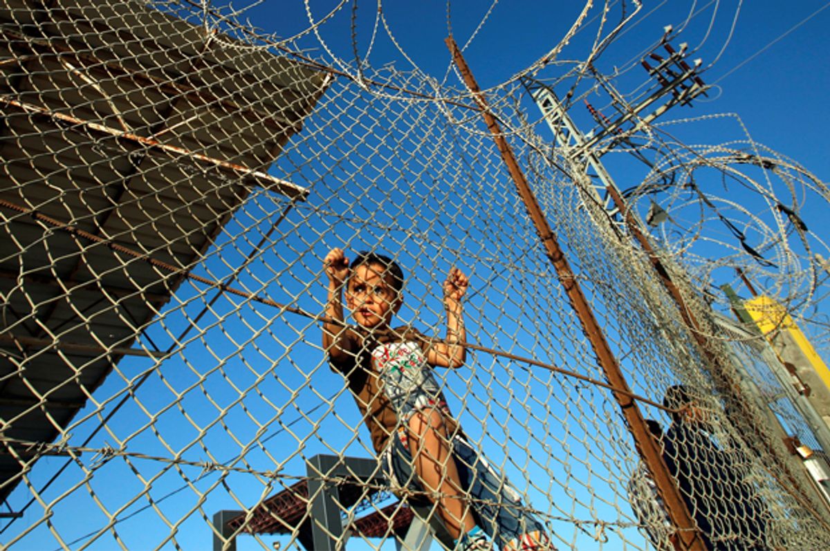 A Palestinian boy stands behind a fence in the southern Gaza Strip, May 12, 2016.   (Reuters/Suhaib Salem)