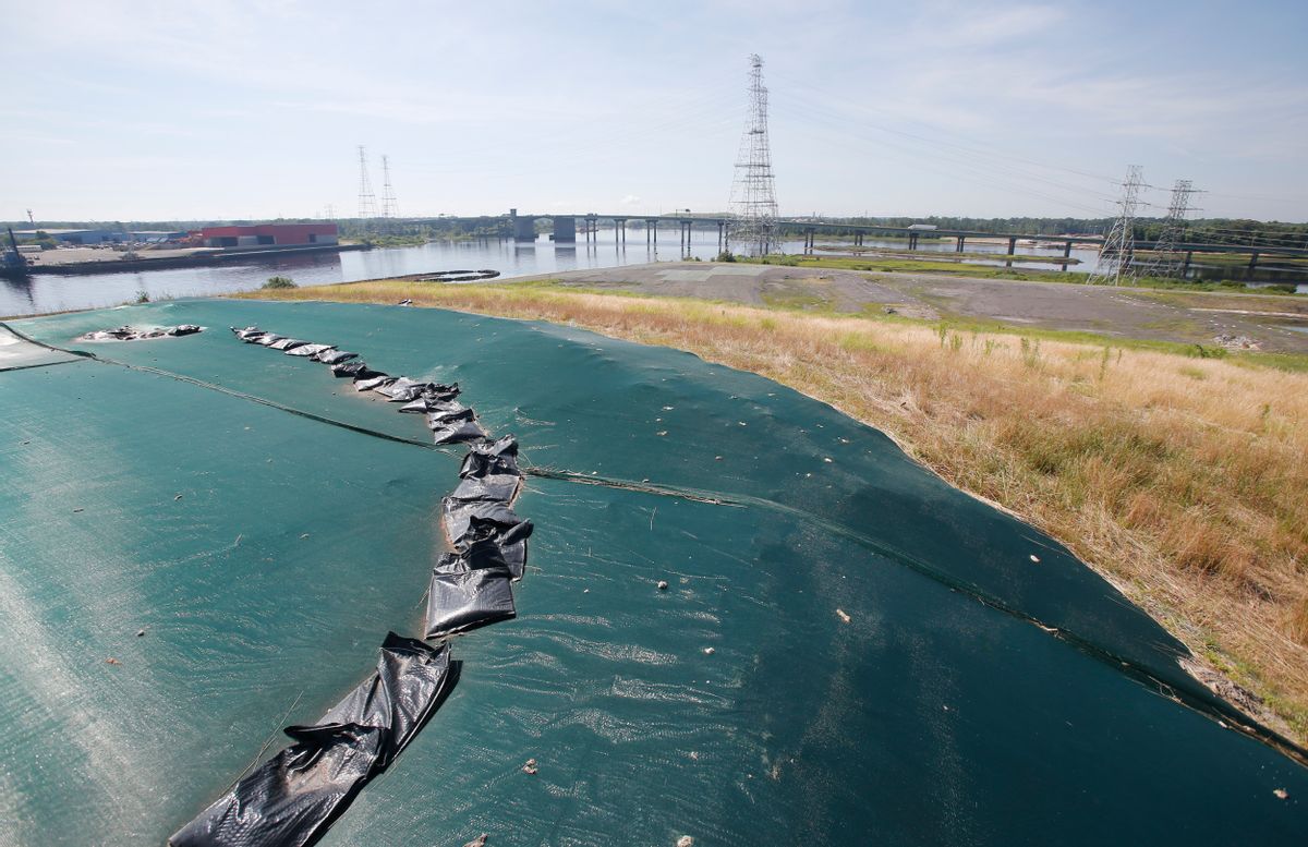 A non-permeable cover tops Coal Ash Basin B along the banks of the Elizabeth River in Chesapeake, Va., Monday, June 27, 2016. A lawsuit has gone to a judge over environmentalists claim that there are leaks of arsenic and other heavy metals into a river near Dominion�s abandoned Chesapeake power plant from the coal Ash pits in violation of the Clean Water Act. (AP Photo/Steve Helber) (AP)