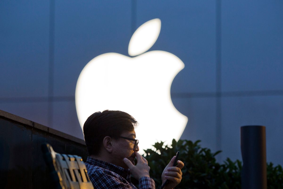 FILE - In this Friday, May 13, 2016, file photo, a man uses his mobile phone near an Apple store in Beijing. Apple reports financial results Tuesday, July 26, 2016. (AP Photo/Ng Han Guan, File) (AP)