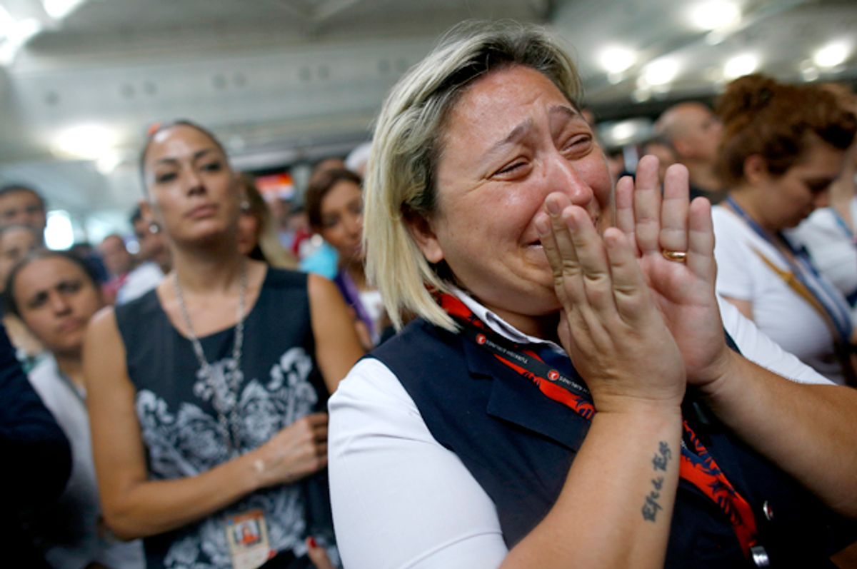 A woman reacts as Family members, colleagues and friends of the victims of Tuesday blasts gather for a memorial ceremony at the Ataturk Airport in Istanbul, Thursday, June 30, 2016.   (AP/Emrah Gurel)