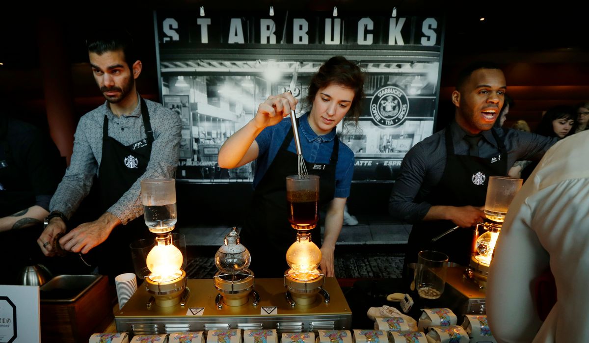 FILE - In this Wednesday, March 23, 2016, file photo, Starbucks workers prepare coffee using siphon vacuum coffee makers at a station in the lobby of the coffee company's annual shareholders meeting in Seattle. Starbucks says that it will be boosting the base pay of all employees and store managers at U.S. company-run stores by 5 percent or more on Oct. 3. In a letter sent to workers on Monday, July 11, 2016, CEO Howard Schultz said that the amount of the raise will be determined by geographic and market factors. (AP Photo/Ted S. Warren, File) (AP)