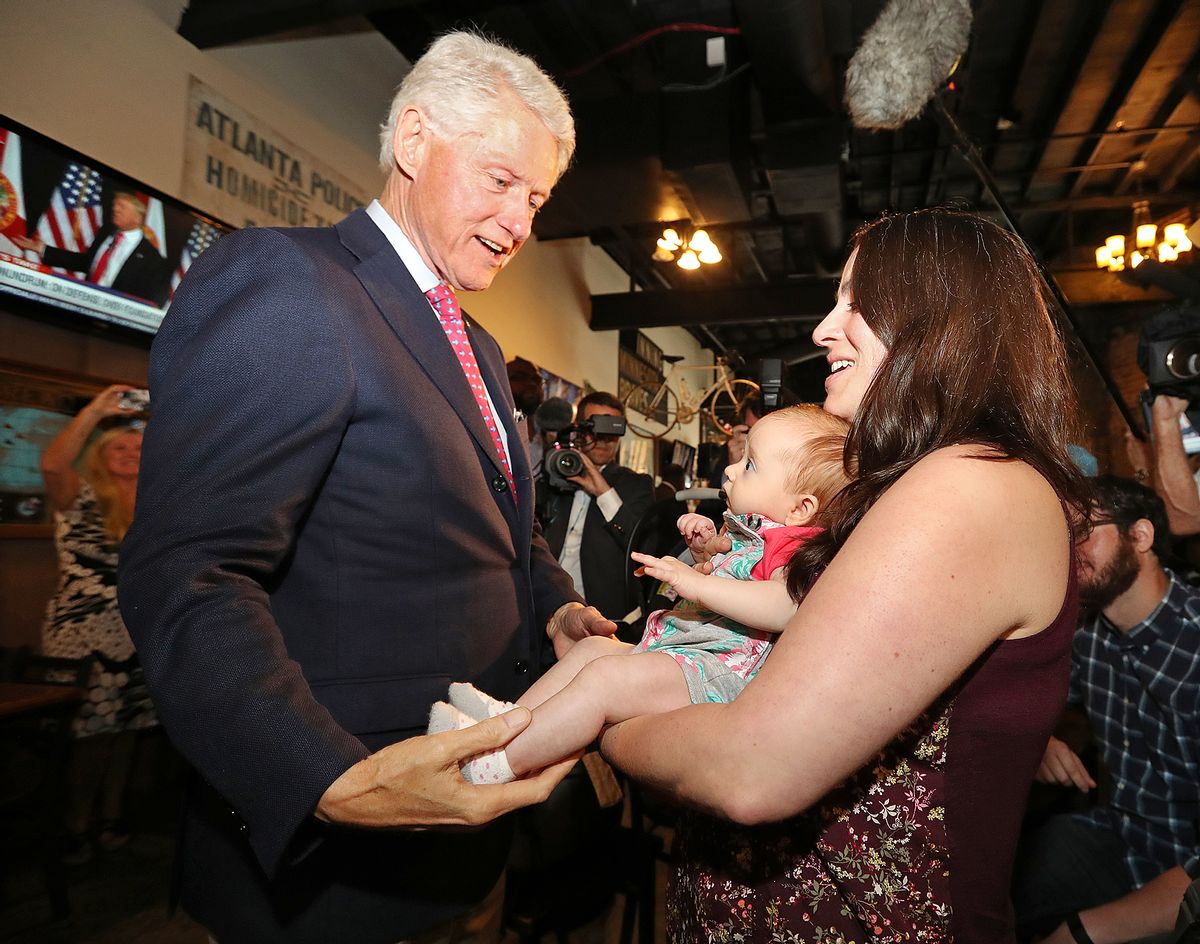 Former President Bill Clinton, left, says hello to Megan Bartlett, of Decatur, Ga., and her 3-month-old daughter Hannah Rice, as he works the crowd at historic Manuel's Tavern, Wednesday, Aug. 24, 2016, during a stop in Atlanta. (Curtis Compton/Atlanta Journal-Constitution via AP) (AP)