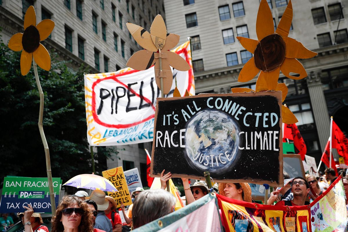 FILE - In this Sunday, July 24, 2016 file photo, climate change activists carry signs as they march during a protest in downtown in Philadelphia a day before the start of the Democratic National Convention. Matthew Nisbet, a communications professor at Northeastern University, says the split with science is most visible and strident when it comes to climate change because the nature of the global problem requires communal joint action, and “for conservatives that’s especially difficult to accept.” He and other experts say climate change is more about tribalism, or who we identify with politically and socially. Liberals believe in global warming, conservatives don’t. (AP Photo/John Minchillo) (AP)