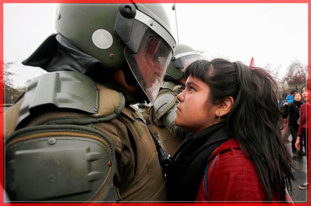 A demonstrator looks at a riot policeman during a protest marking the country's 1973 military coup in Santiago, Chile September 11, 2016. REUTERS/Carlos Vera FOR EDITORIAL USE ONLY. NO RESALES. NO ARCHIVE.     TPX IMAGES OF THE DAY      - RTSN9Z3 (Reuters)