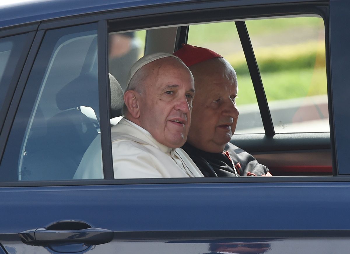 In this July 31, 2016 file photo pope Francis and Krakow cardinal Stanislaw Dziwisz, right, are arriving in a navy blue Volkswagen Golf car to celebrate a Holy Mass there. The car, along with two other similar VW Golf care that Francis was driven in in Poland has been put on auction by a Polish Catholic Church charity to raise funds for a mobile clinic for Syrian refugees in Lebanon and for a shelter for the disabled in Poland. (AP)