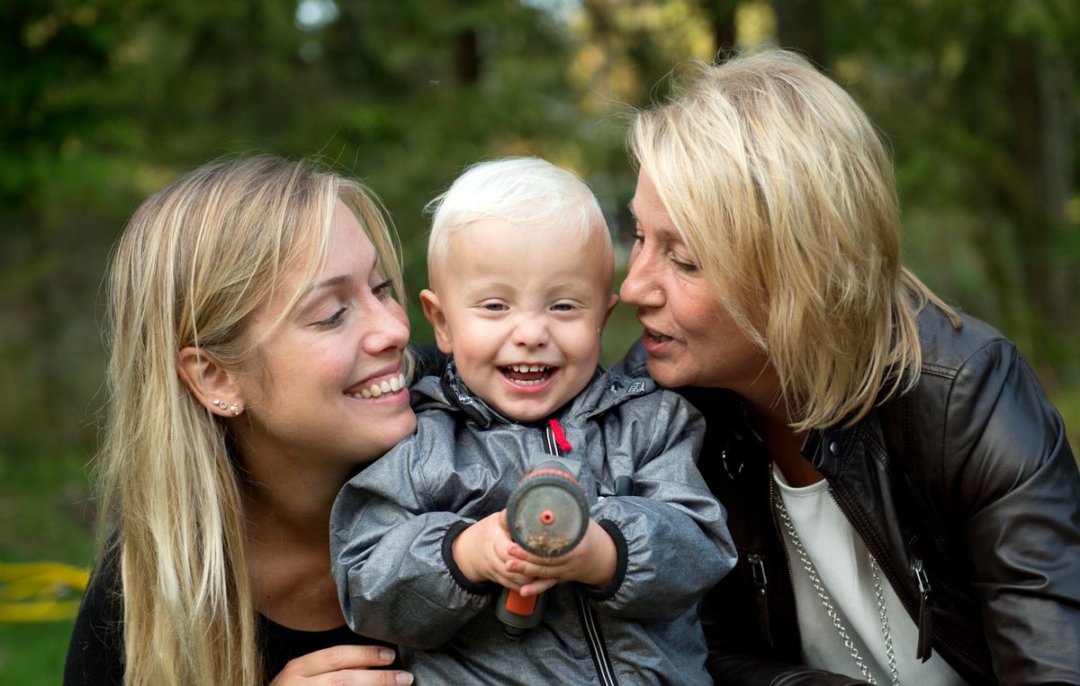 In this photo taken Tuesday, Sept. 20, 2016, Albin's mother Emelie Eriksson, left, smiles as she poses for a photo with her son and her mother Marie, right, outside her home in Bergshamra, Sweden. Eriksson was the first woman to have a baby after receiving a womb transplant from her mother, a revolutionary operation that links three generations of their family. (AP Photo/ Niklas Larsson) (AP Photo/ Niklas Larsson)