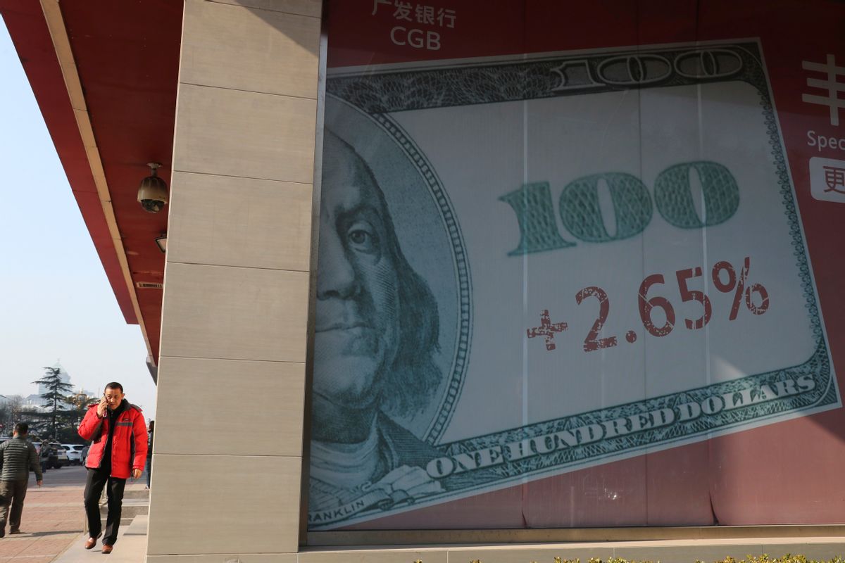 A man walks past a billboard with the U.S. currency displayed on its outside a bank in Beijing, China, Thursday, Nov. 24, 2016.  (AP)