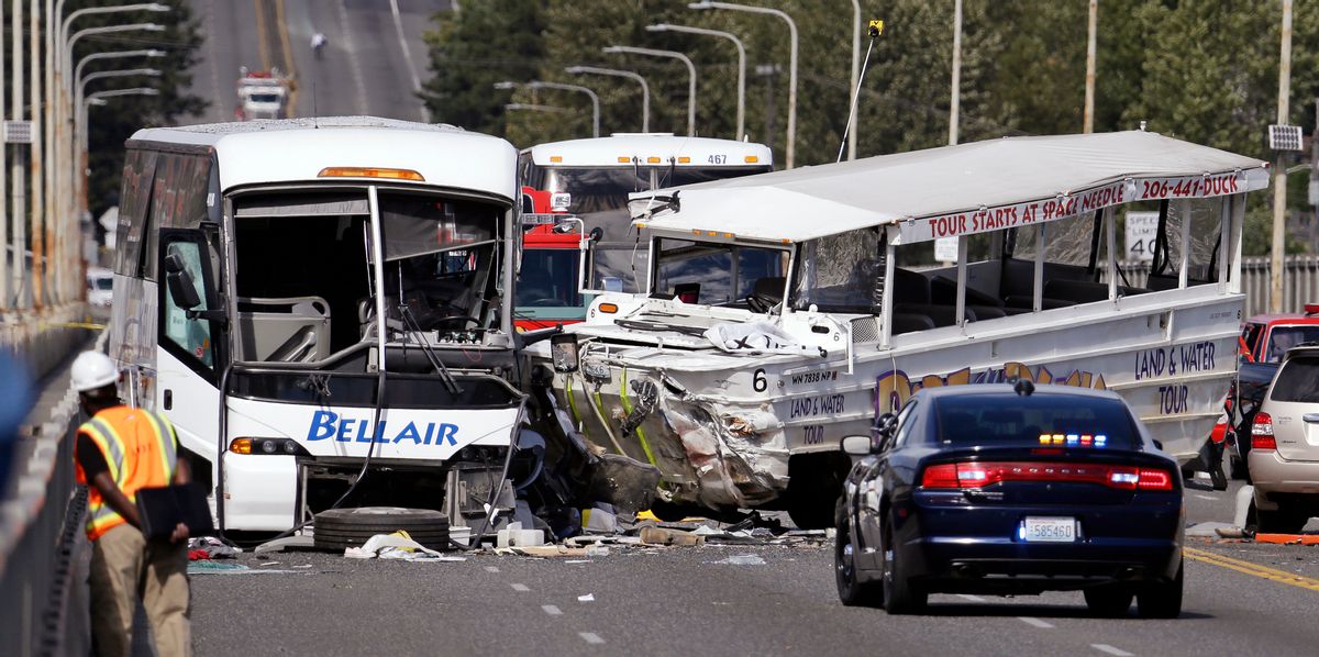 FILE - In this Sept. 24, 2015, file photo, a "Ride the Ducks" amphibious tour bus, right, and a charter bus remain at the scene of a fatal collision on the Aurora Bridge in Seattle. The National Transportation Safety Board meets Tuesday, Nov. 15, 2016, to determine the probable cause of the crash of the Ride the Ducks vehicle after it crossed the center line into oncoming traffic while driving over the bridge. It hit a charter bus full of college students, killing five. (AP Photo/Elaine Thompson, File) (AP)