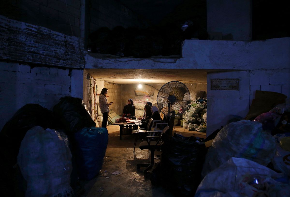 In this Friday, Oct. 28, 2016 photo, Syrian refugee Haela Kalawi, 31, second left, and fellow Syrian refugees sit on a sofa surrounded by the garbage as they attend an English class at Recycle Beirut, their work place in Ouzai, a poor neighborhood in the Lebanese capital of Beirut. About one-third of 240,000 Syrian refugee households in Lebanon are headed by women, in stark contrast to Syria's traditions which see men as providers and protectors. The husbands of the women surviving on their own are either dead, missing, chose to remain in Syria or tried to make their way to Europe. (AP Photo/Bilal Hussein) (AP)