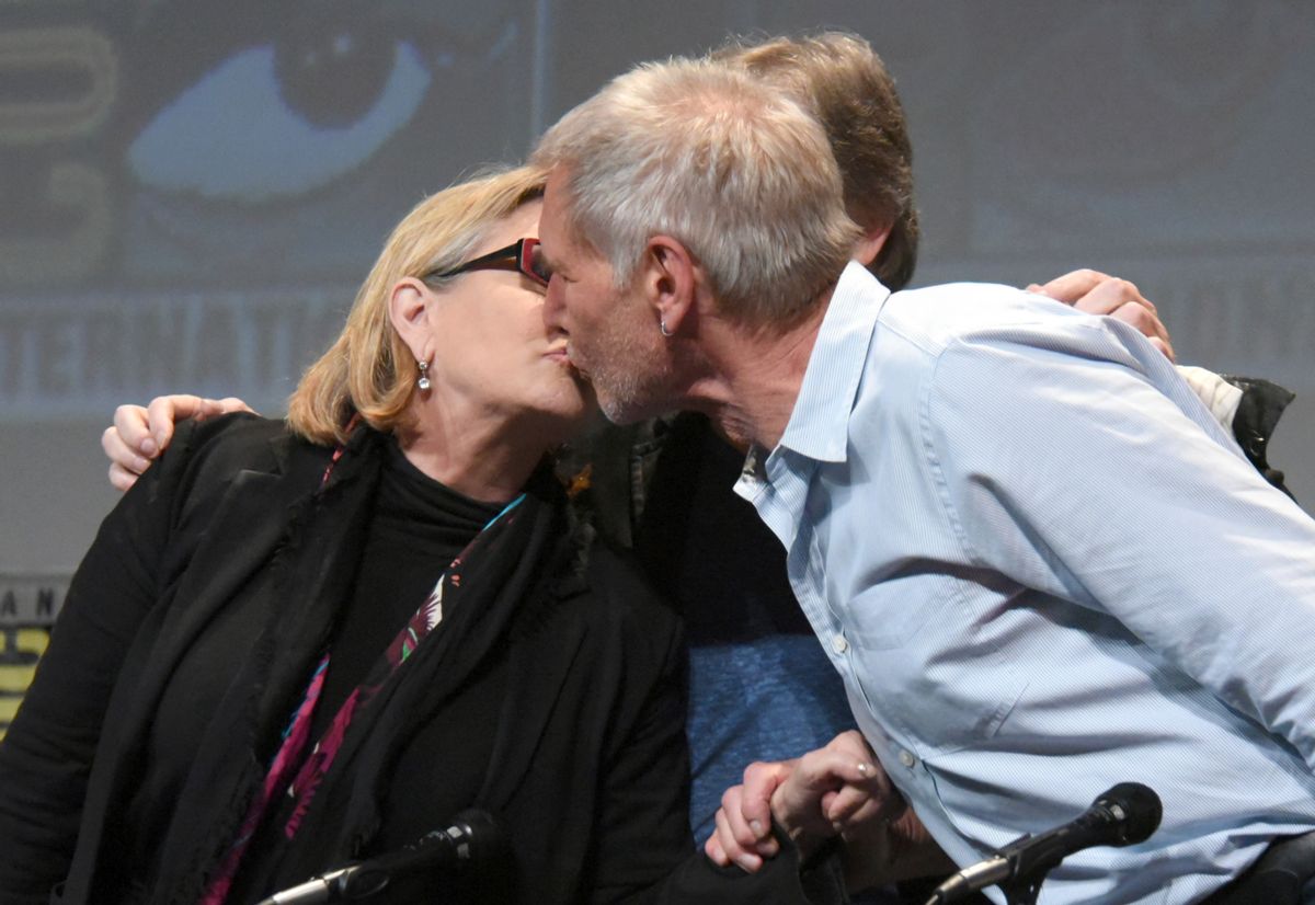 FILE - In this July 10, 2015, file photo, Carrie Fisher, left, and Harrison Ford kiss at the Lucasfilm's "Star Wars: The Force Awakens" panel on day 2 of Comic-Con International in San Diego, Calif. Fisher, a daughter of Hollywood royalty who gained pop-culture fame as Princess Leia in the original "Star Wars" and turned her struggles with addiction and mental illness into wickedly funny books, a hit film and a one-woman stage show, died Tuesday, Dec. 27, 2016. (Photo by Richard Shotwell/Invision/AP, File) (AP)