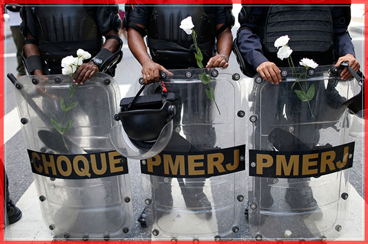 Police officers stand with flowers given to them by demonstrators during a protest against austerity measures outside the state legislature, in Rio de Janeiro, Brazil, Monday, Dec. 12, 2016. Police, firefighters and school teachers are among the workers for Brazil’s Rio de Janeiro state protesting against government austerity measures being considered by lawmakers. (AP Photo/Silvia Izquierdo) (AP)