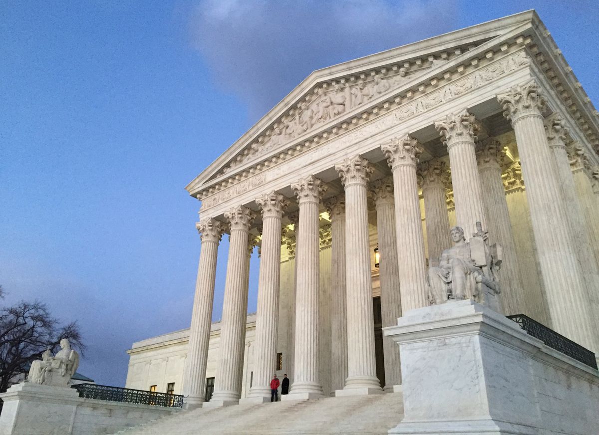 FILE - In this Feb. 13, 2016, file photo, people stand on the steps of the Supreme Court at sunset. The Supreme Court is returning to the familiar intersection of race and politics, in a pair of cases examining redistricting in North Carolina and Virginia. The eight-justice court is hearing arguments Dec. 5, in two cases that deal with the same basic issue of whether race played too large a role in the drawing of electoral districts, to the detriment of African-Americans. (AP Photo/Jon Elswick, file) (AP)