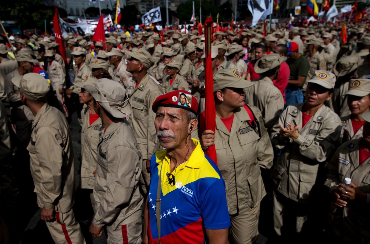 A supporter of Venezuela's President Nicolas Maduro, wearing a red beret is flanked by member of the militia during a rally in Caracas, Venezuela, Saturday, Dec. 17, 2016.  (AP Photo/Fernando Llano) (AP)